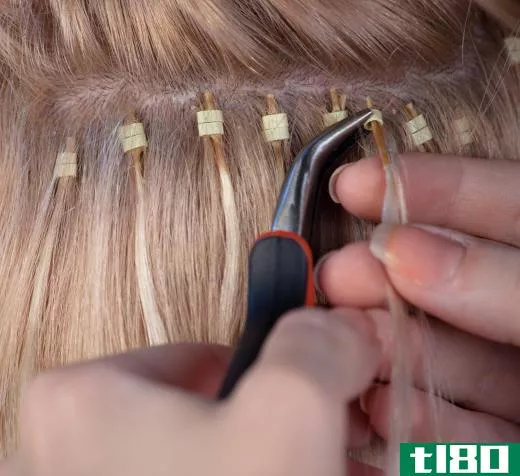 A stylist putting in hair extensions.