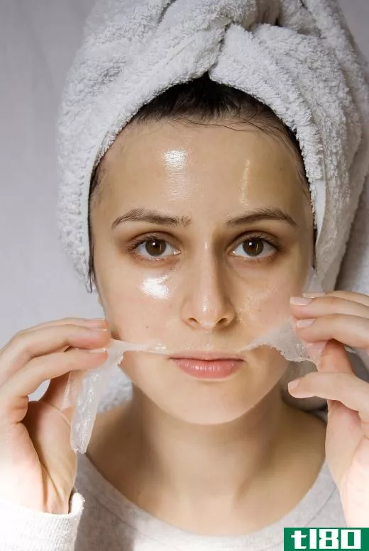 A woman removing a collagen facial mask.