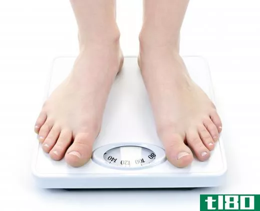 With a mechanical bathroom scale, a dial turns to display a person's weight.