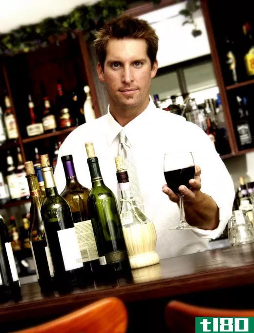 Bartender serving a glass of screw-cap wine.