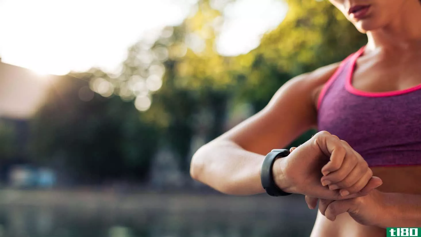 A woman in fitness clothes looking at her watch