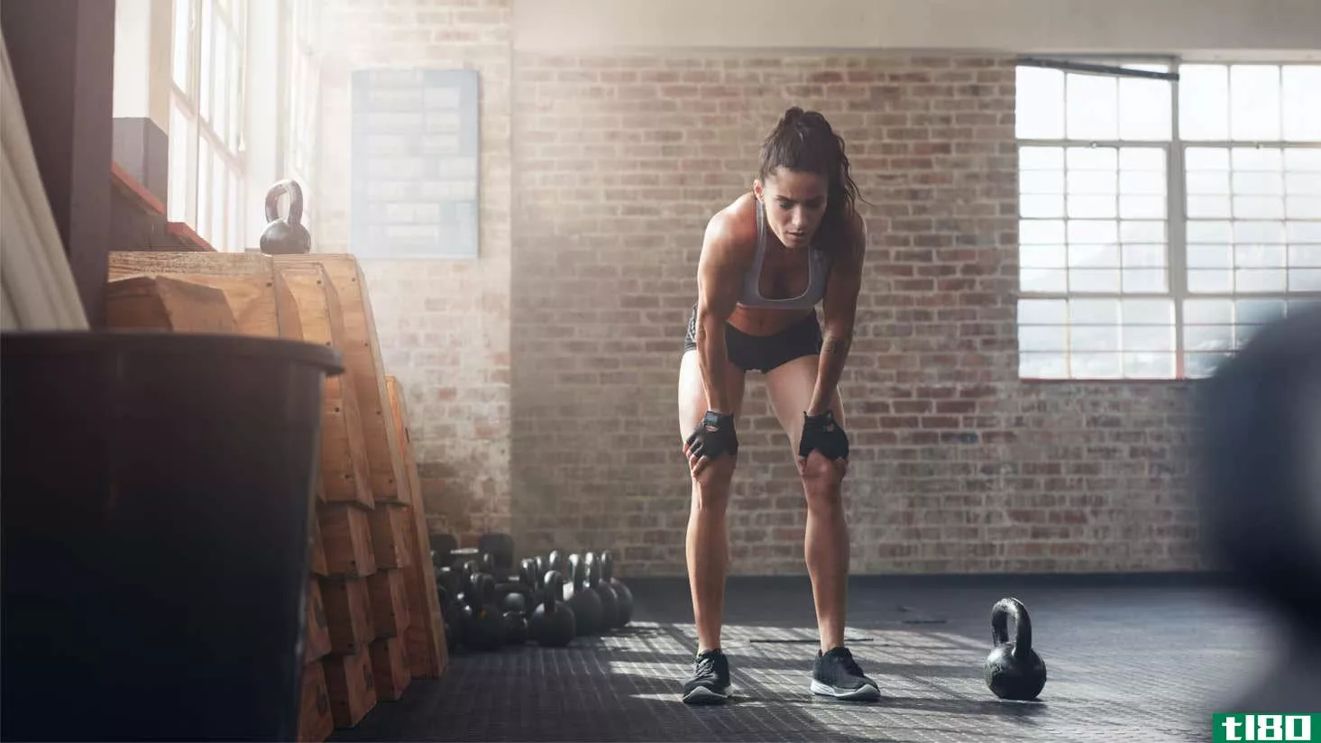 woman looking exhausted next to a kettlebell