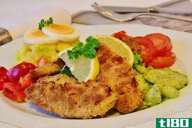 chicken schnitzel, lemon slices and tomatoes