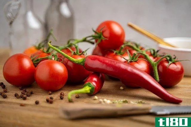 tomatoes and peppers on wooden cutting board
