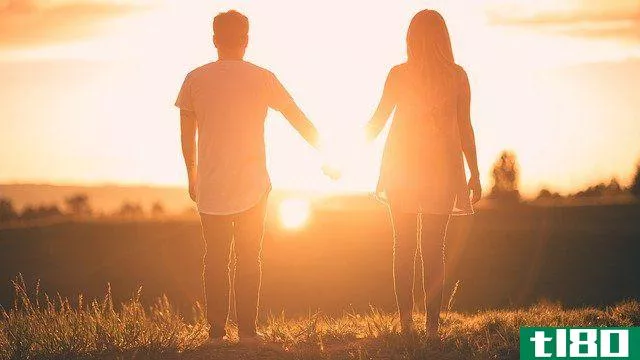 couple holding hands while watching the sunset