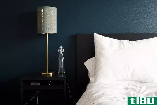 Gray lamp on bedside table next to a bed