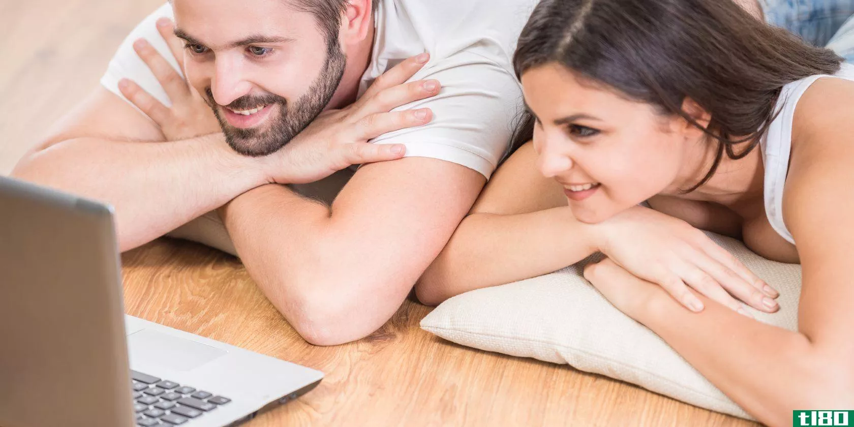 young-beautiful-couple-lying-on-the-floor-at-home-and-watching-movie-on-laptop