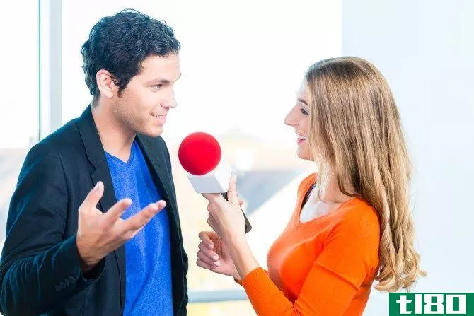 woman interviewing man with microphone