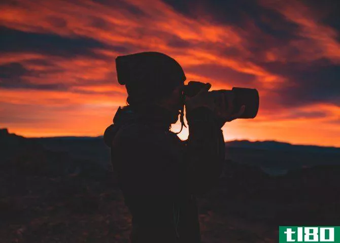 Person holding a camera at sunset