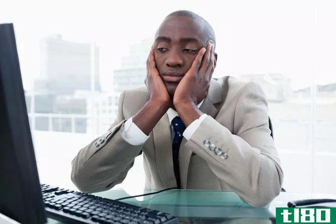 Bored busines**an looking at his computer in his office