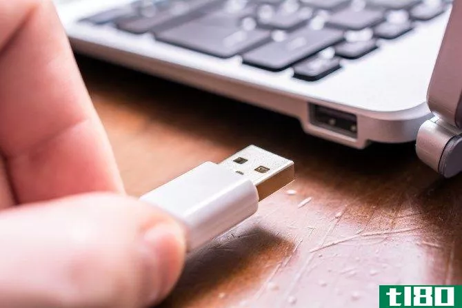 Man Unplugging USB Device from Computer