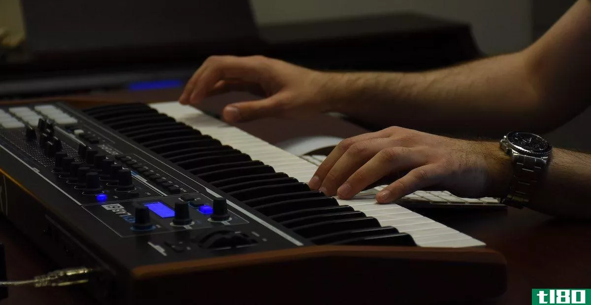 A person playing a keyboard wearing a watch.