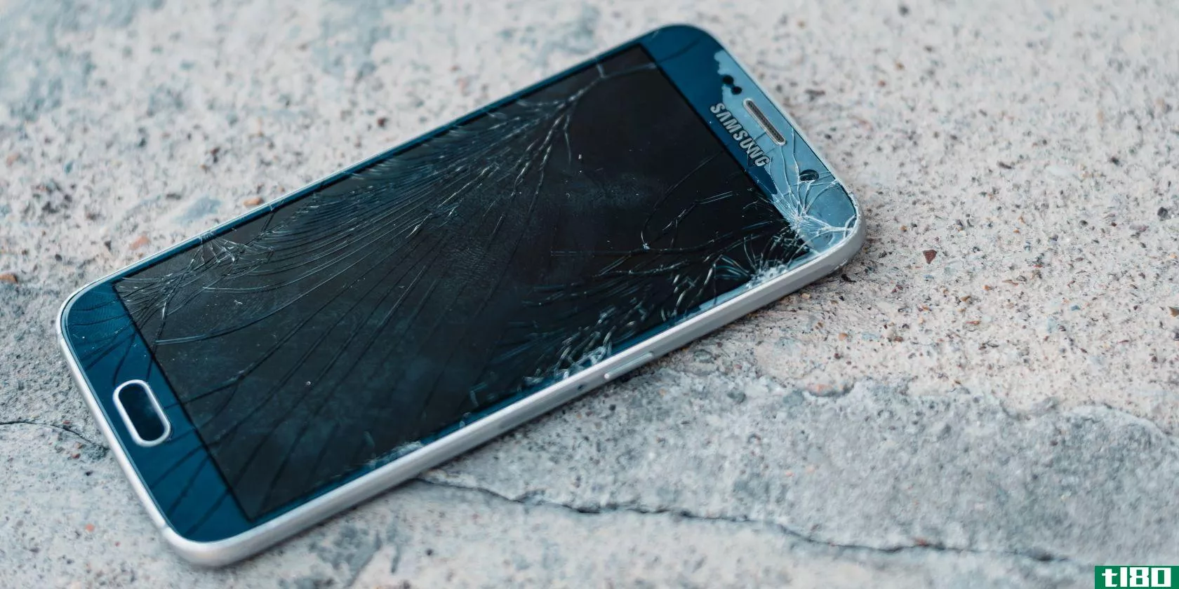A cell phone with a dark screen covered in cracks
