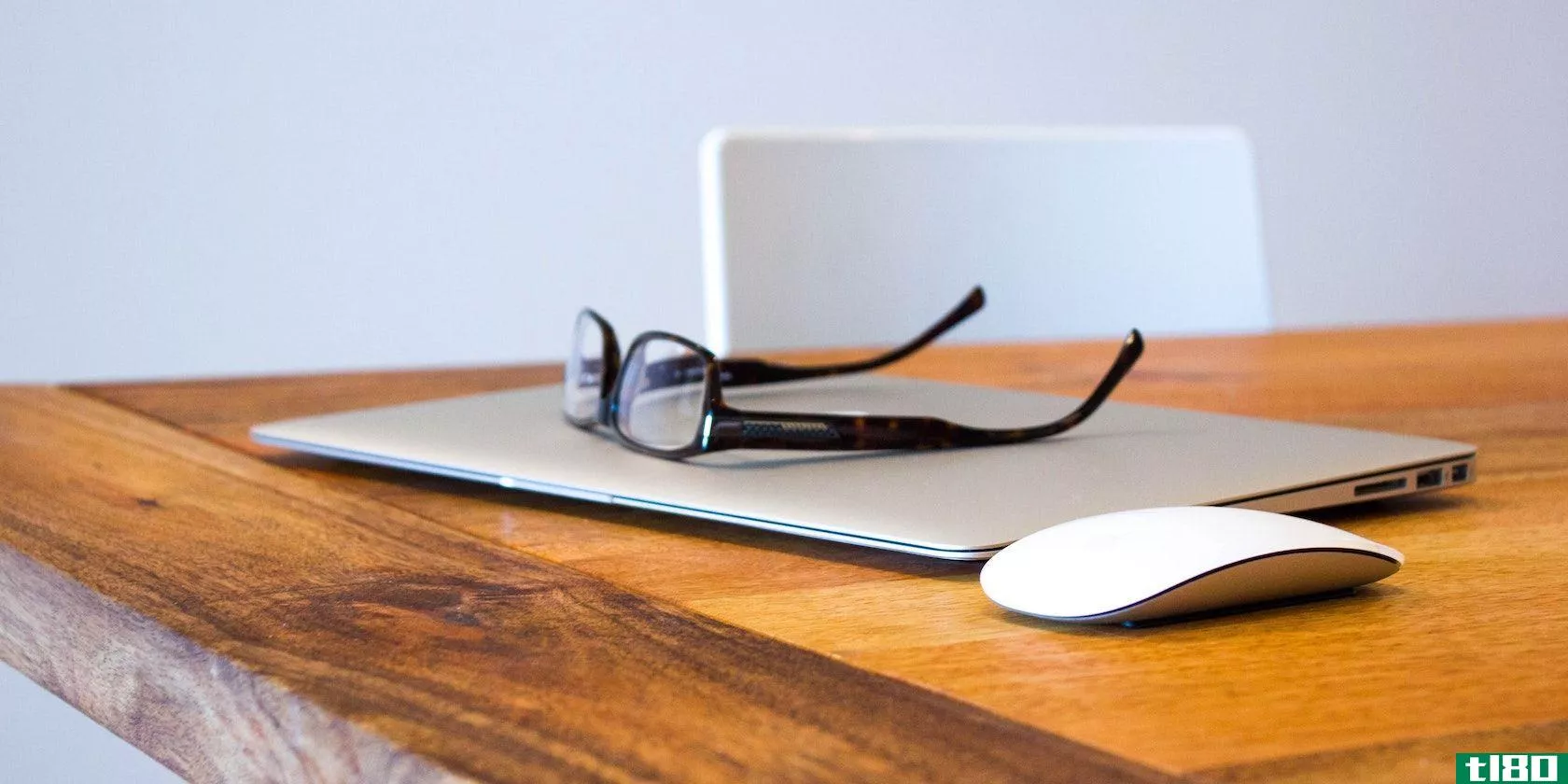 A photograph of a pair of spectacles sitting on top of a closed Macbook