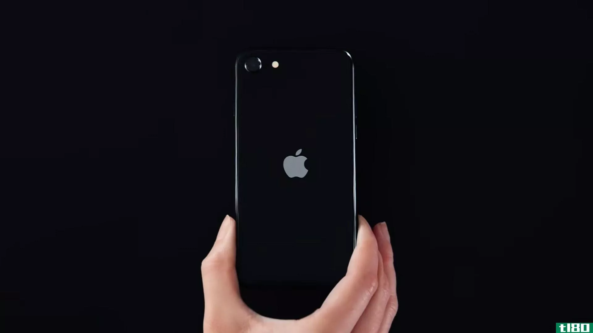 A still from an Apple ad showing a black iPhone SE (2020)