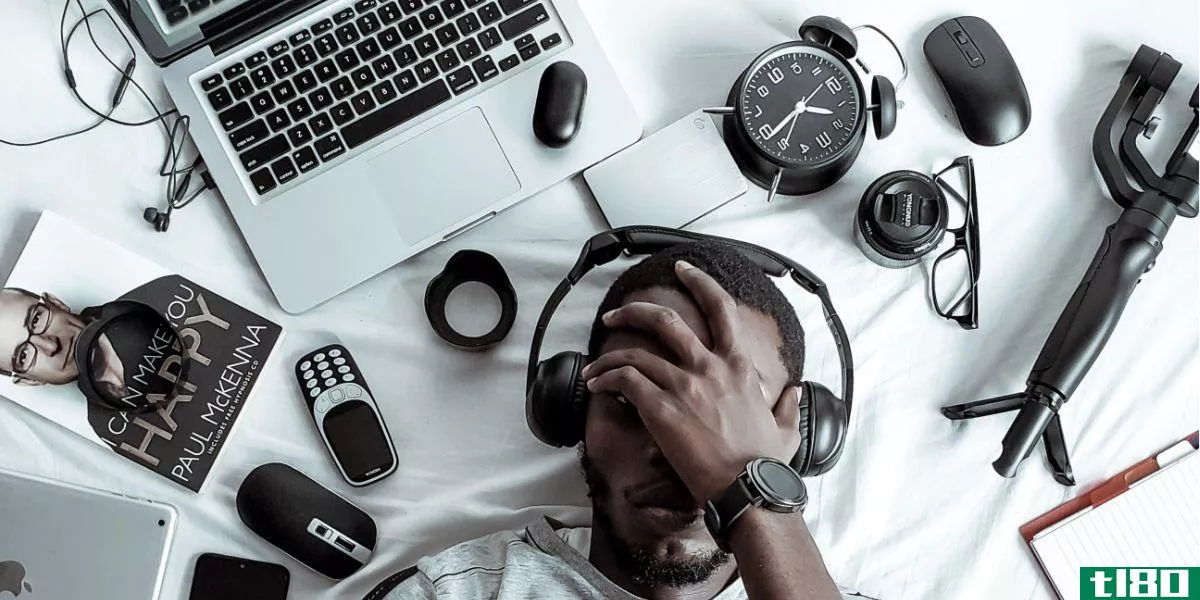 Man laying in front of various tech items