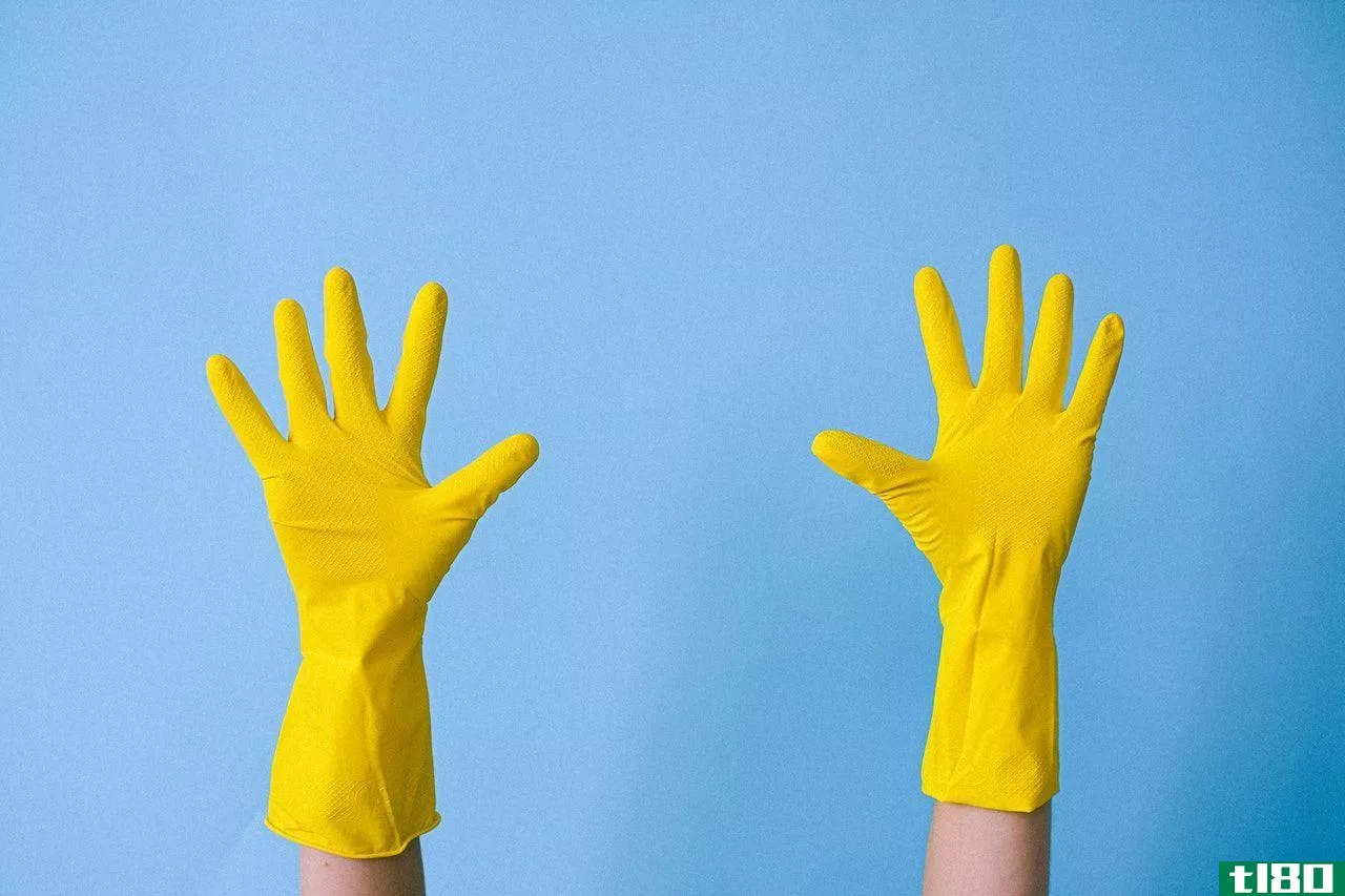 two hands with yellow gloves