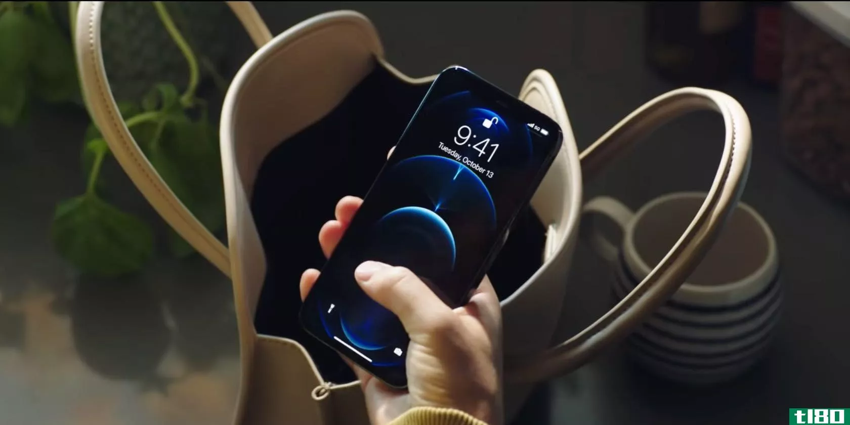 A still from an Apple ad showing a woman holding an iPhone 12 in her hand, pressing the Lock screen with a thumb