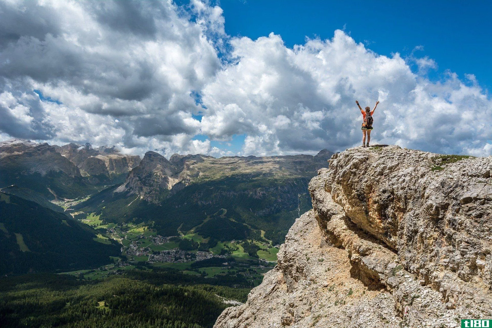 person standing triumphant on top of a mountain featured