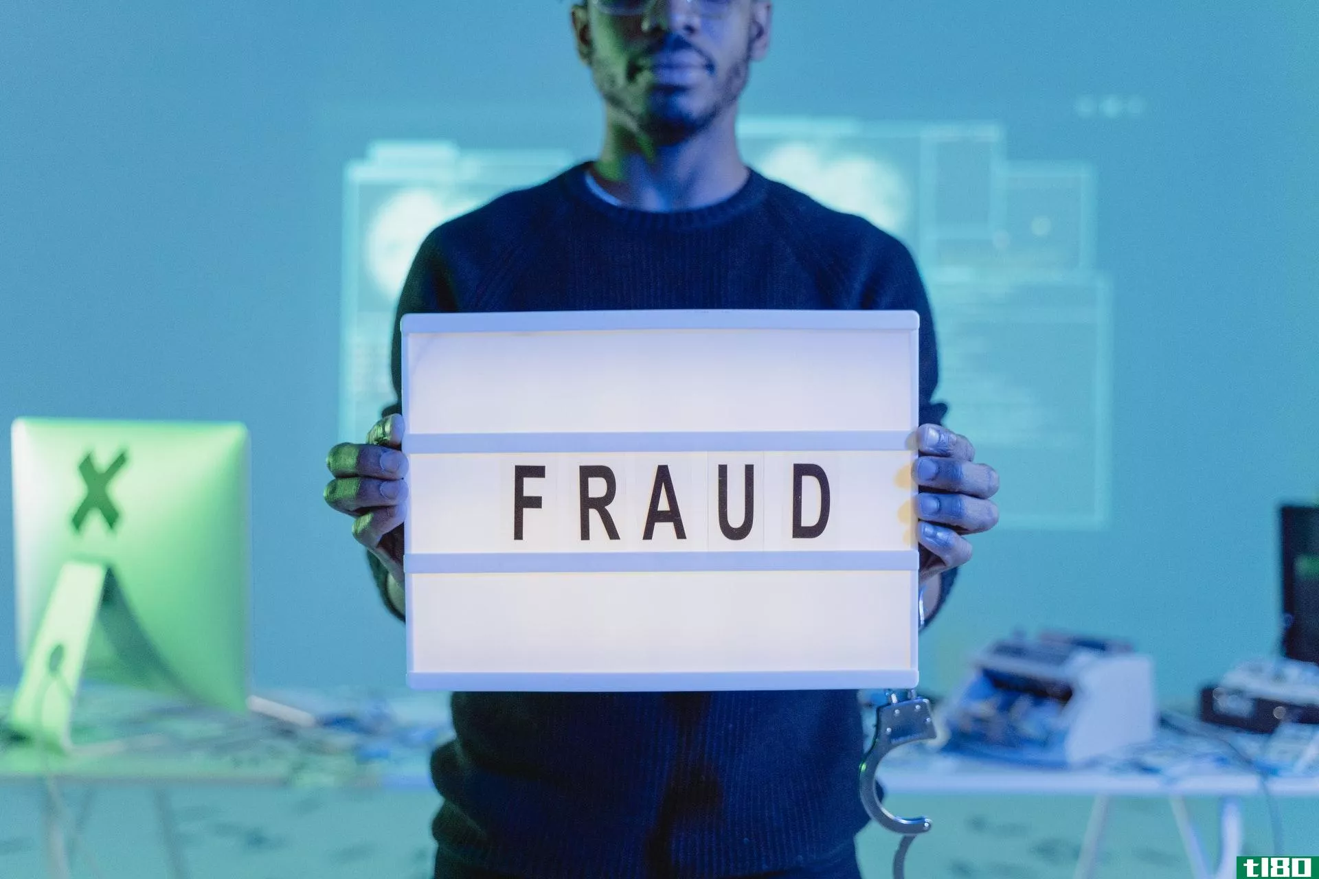Man holding a laptop with fraud written on it