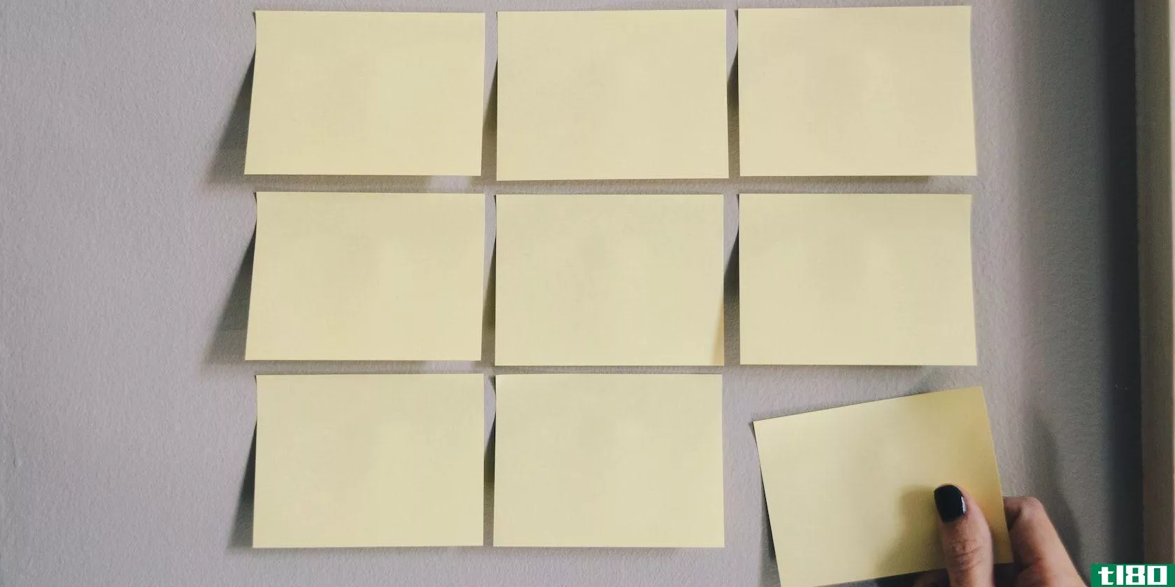 A grid of yellow sticky notes with a hand removing the lower right note