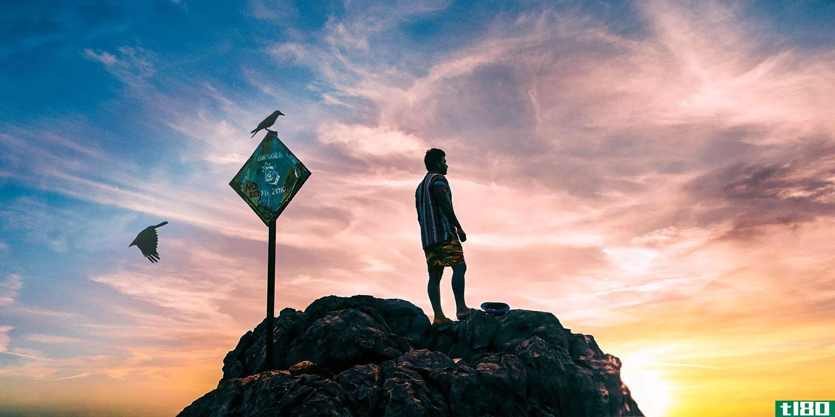 Man standing on rock at sunset