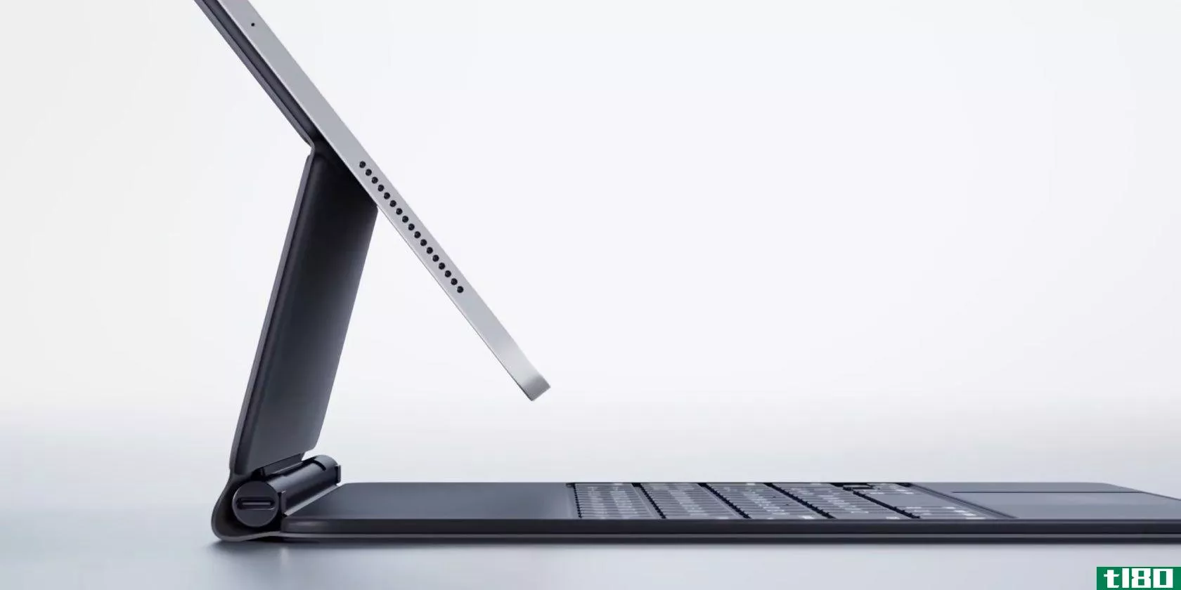 A profile view of a 12.9-inch iPad Pro (2018 model) suspended mid-air on a Magic Keyboard