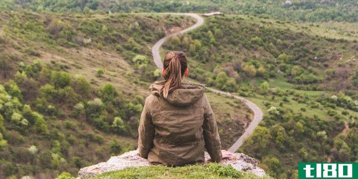 the back of a woman overlooking a winding path