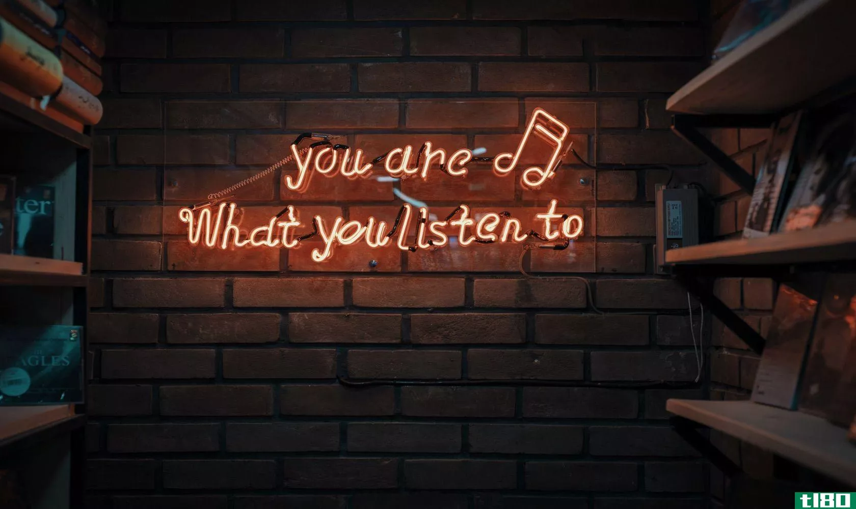 Neon sign on wall that says you are what you listen to