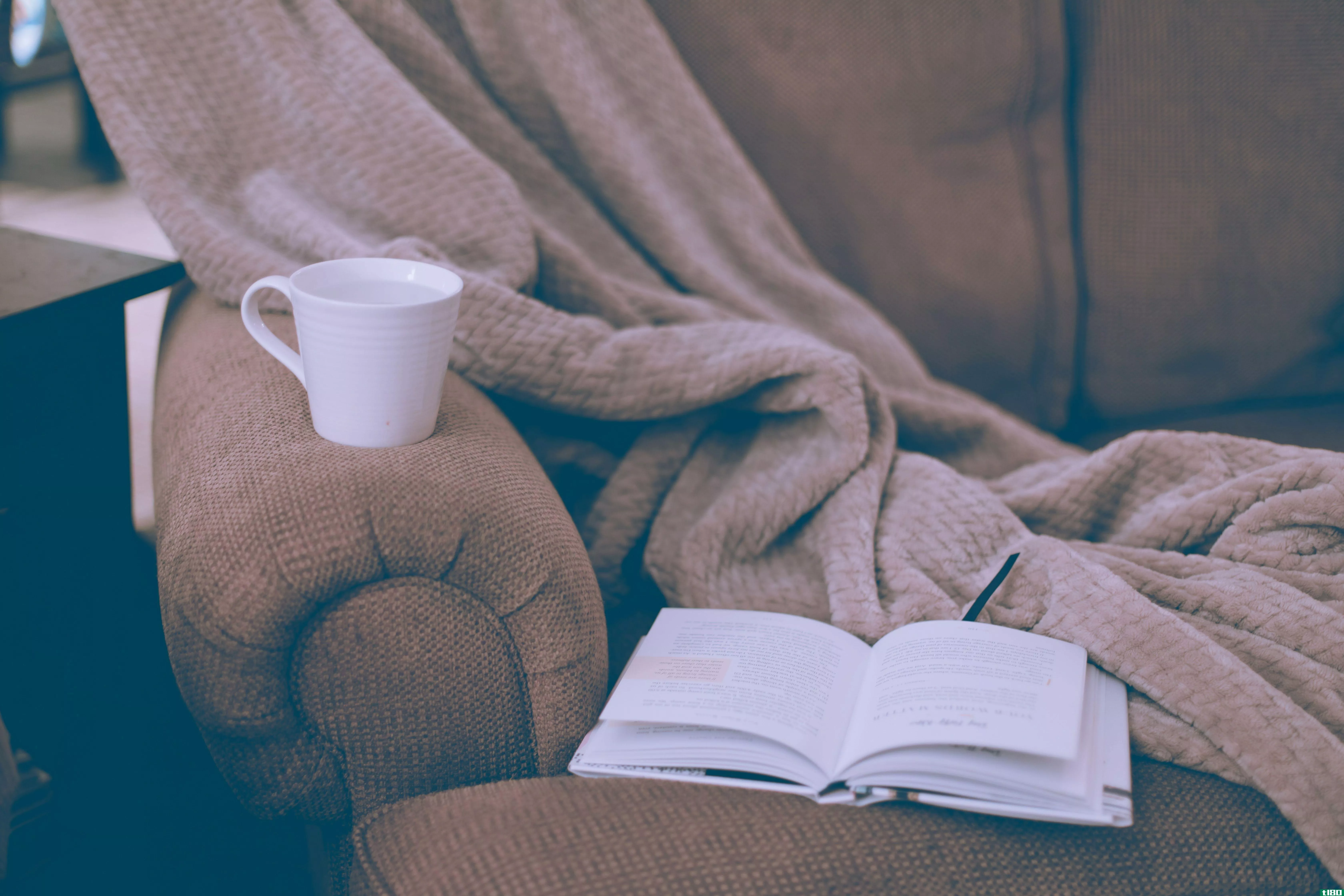 Book and coffee cup on couch