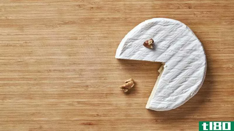 a wheel of brie eating walnuts as if it's pac-man