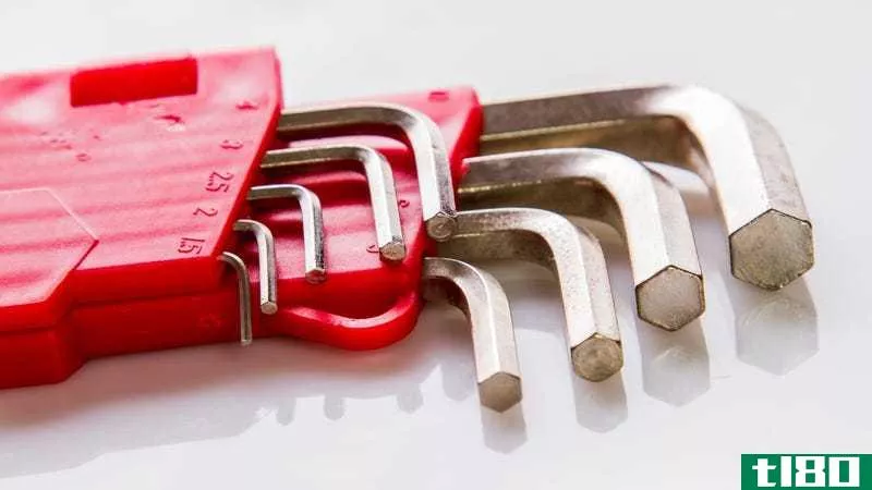 A set of metal Allen wrenches in a red plastic holder on a white background