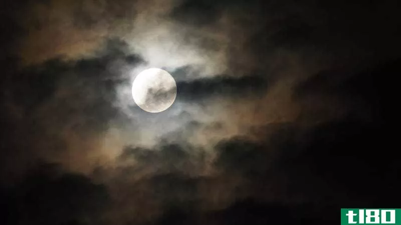 The full moon in a dark, cloudy night sky