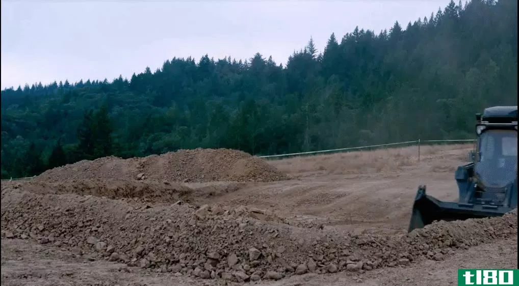 观看这台无人驾驶的自动推土机挖掘泥土