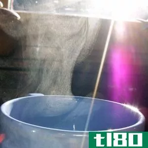 Condensing water droplets above a cup of hot coffee (or tea) disperse light and so can be detected when light shines on them.